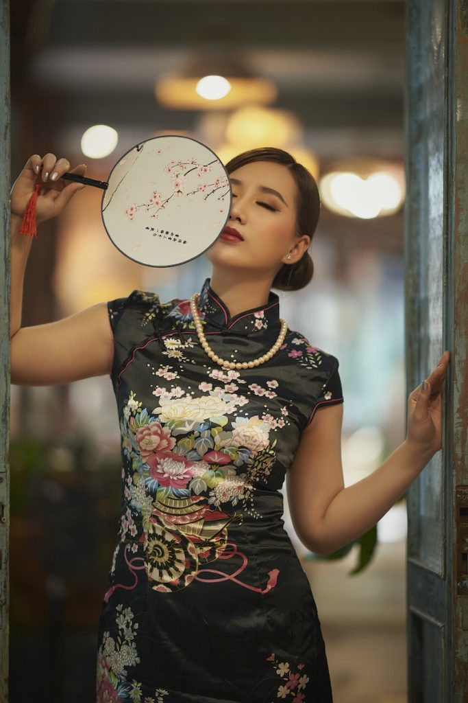 An Elegant Woman in Black Kimono Holding a Hand Fan